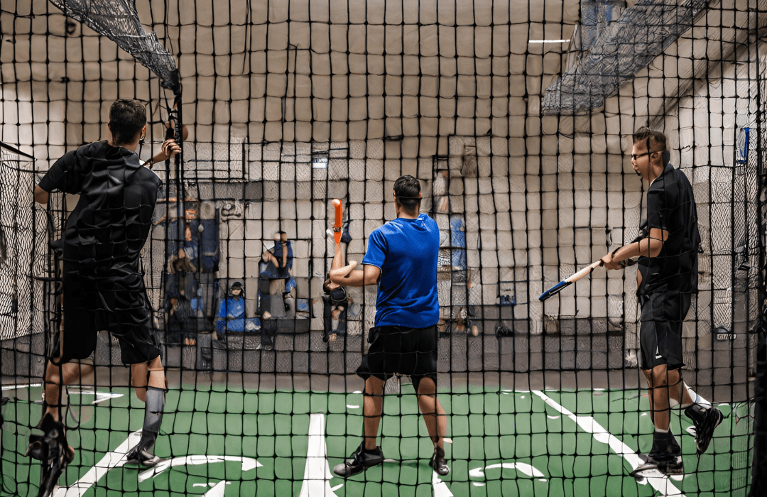 Players playing at baseball batting cage at anytime courts in an indoor sports court